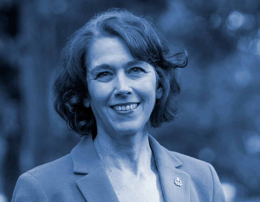 a shoulder up portrait of Wisconsin Supreme Court Candidate, Judge Susan Crawford. She is in front of a background of blurred foliage and the entire image has a blue overlay.