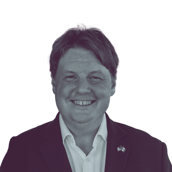 A black and white portrait of Michael Cashman, Democratic candidate for New York Assembly District 115, smiling and looking into the camera.